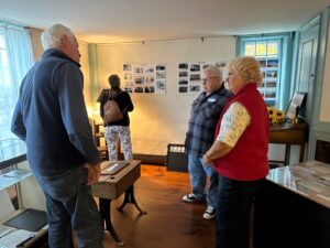 A group of people gathered around an old-style school desk