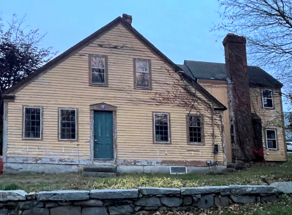 an old house, with peeling paint, on a stone foundation