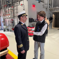 Deputy Chief Sammet in a fire station is pinned by his son, Jordan