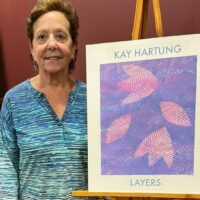 Artist Kay Hartung by the entrance to her exhibit at the Acton Memorial Library. 