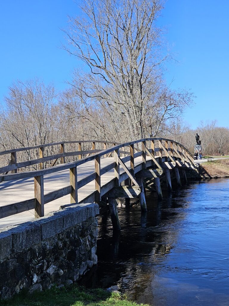 a bridge, with wooden rails, over a river